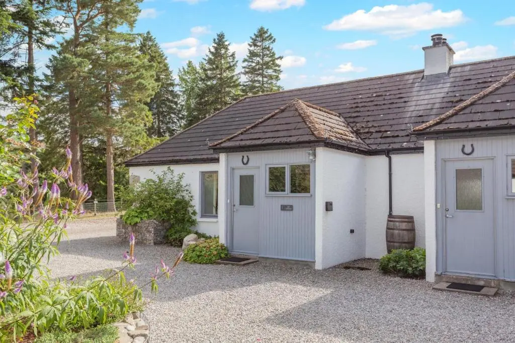 a small white garage with a pitched roof at 1 Bed in Newtonmore oc-a32412 in Newtonmore