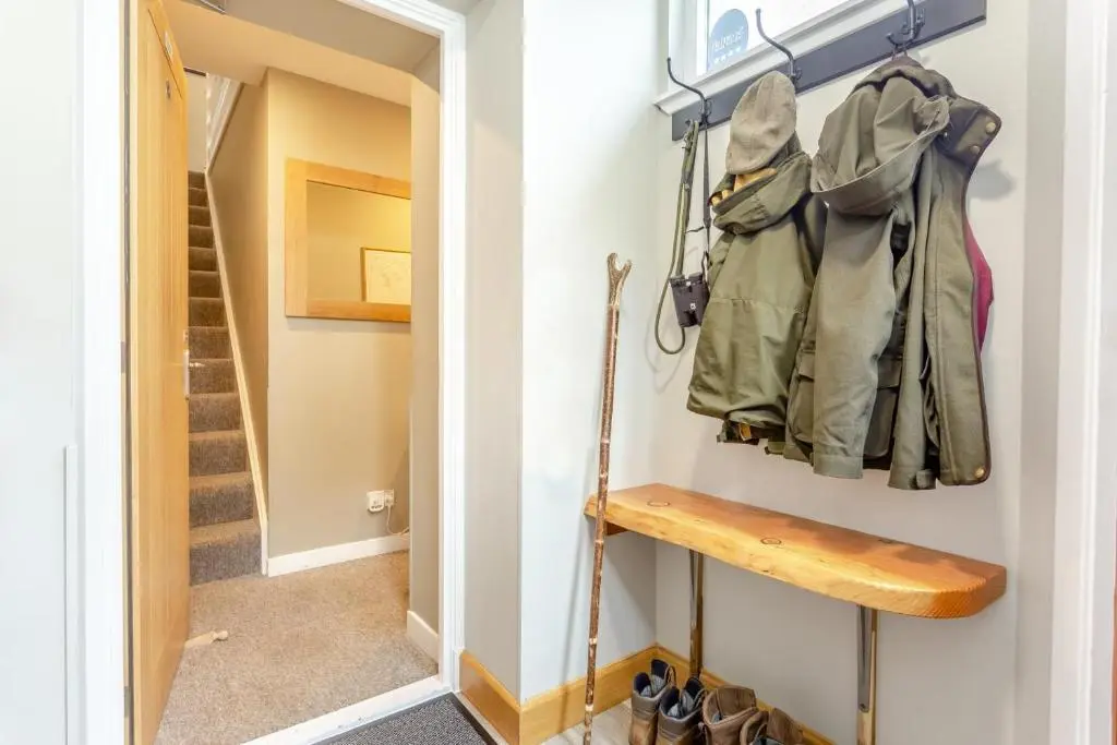 a hallway with a stairway with a coat rack and shoes at 2 Bed in Newtonmore oc-d32413 in Newtonmore