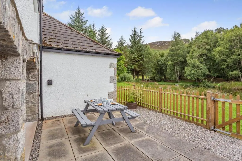 a picnic table outside of a building with a fence at 2 Bed in Newtonmore oc-d32413 in Newtonmore