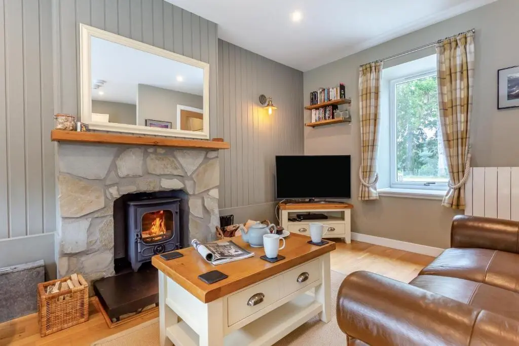 a living room with a fireplace and a television at 2 Bed in Newtonmore oc-d32413 in Newtonmore