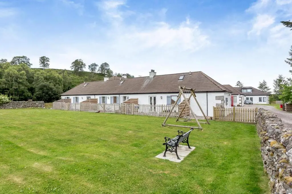 a park with a bench and a swing at 1 Bed in Newtonmore oc-c32414 in Newtonmore
