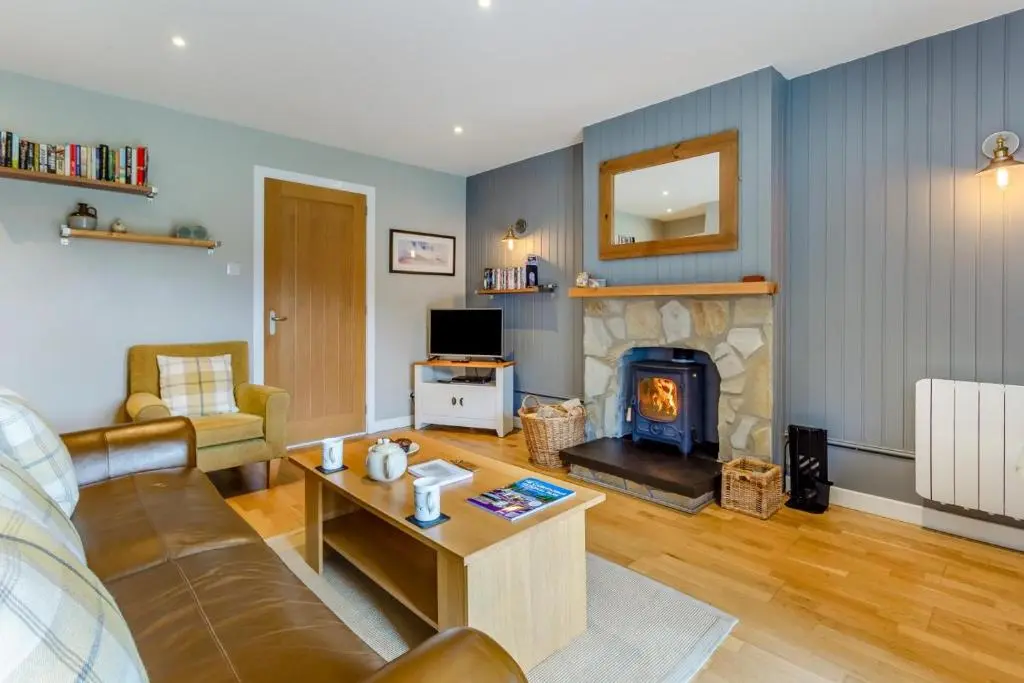 a living room with a couch and a fireplace at 1 Bed in Newtonmore oc-b32417 in Newtonmore