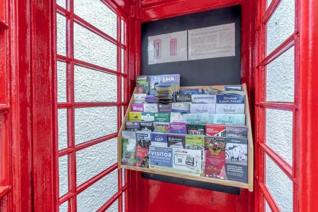 a red phone booth with a bunch of books at 1 Bed in Newtonmore oc-b32417 in Newtonmore