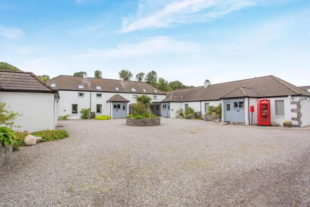 a row of white houses with a red phone booth at 2 Bed in Newtonmore oc-e32418 in Newtonmore