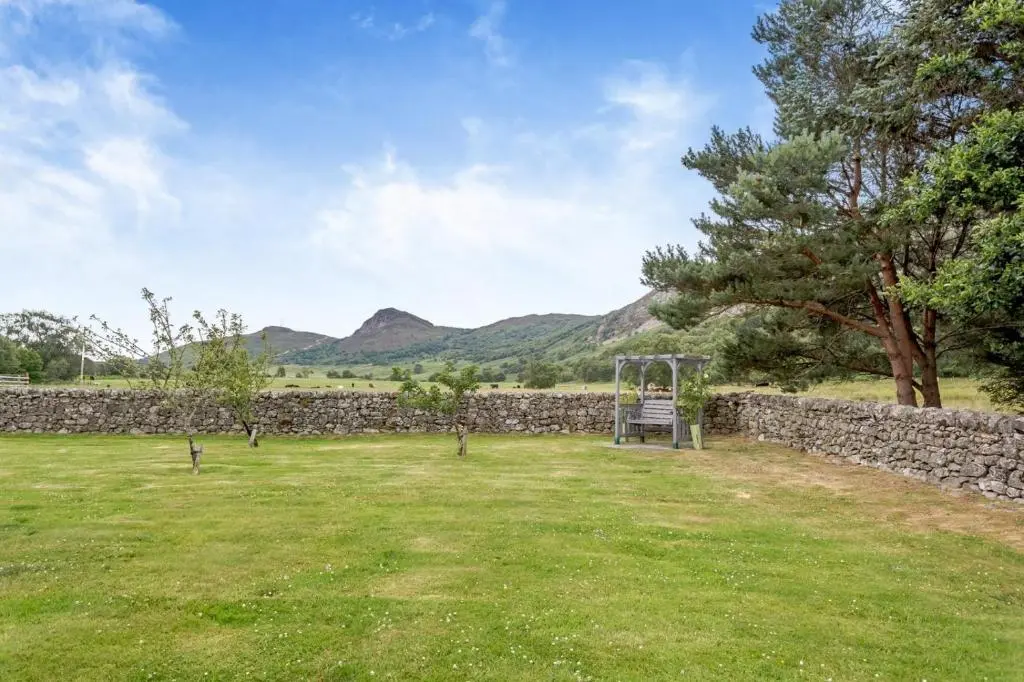 a park with a stone wall and a playground at 3 Bed in Newtonmore oc-h32416 in Newtonmore
