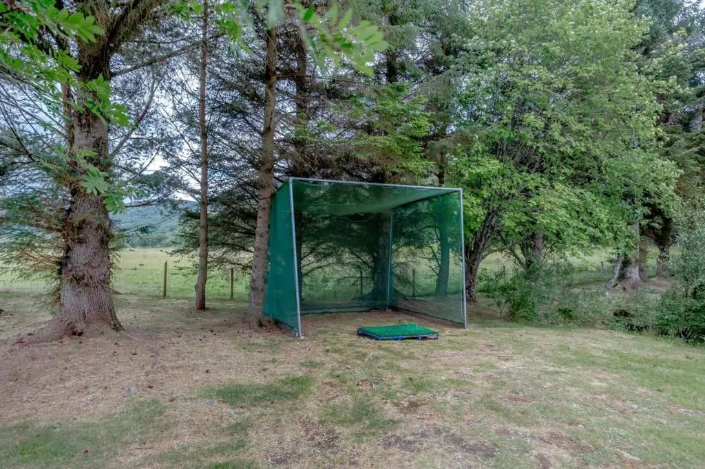 a green tent in a field next to a tree at 3 Bed in Newtonmore oc-h32416 in Newtonmore