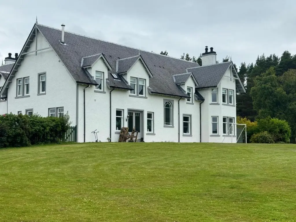 a large white house with a large yard at Daviot Lodge apartment in Daviot