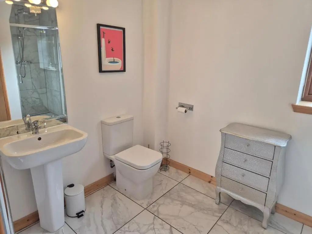 a white bathroom with a sink and a toilet at 2 Bed House - free parking, short walk to City centre in Inverness