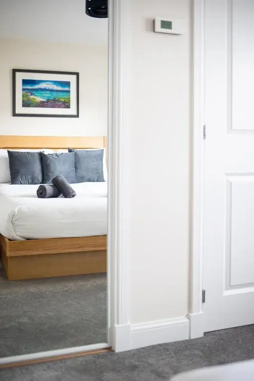 a bedroom with a bed viewed through a mirror at City and Loch Ness Blend in Inverness