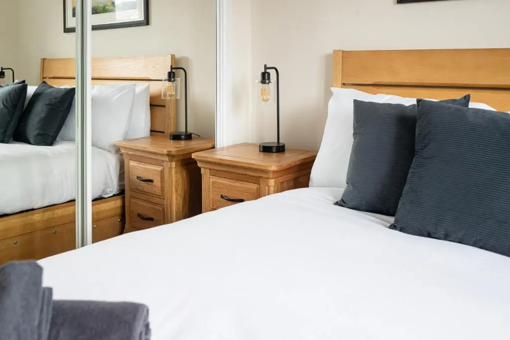 a bedroom with two beds and two lamps at City and Loch Ness Blend in Inverness