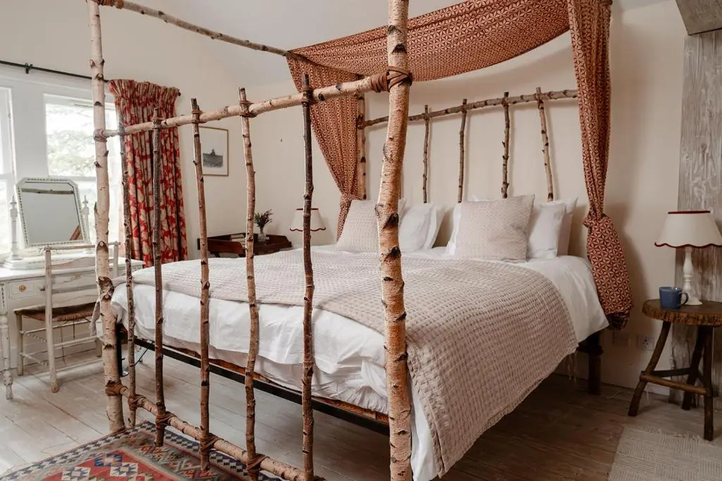 a bedroom with a four poster canopy bed at Glencarnie - Seasgair Lodges in Boat of Garten
