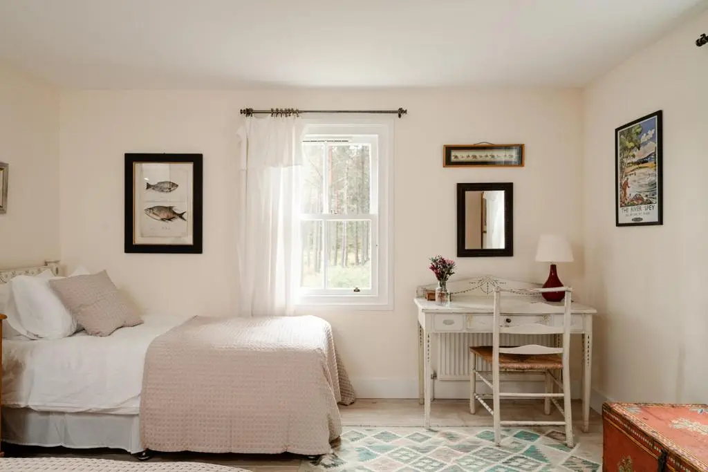 a bedroom with a bed and a desk and a window at Glencarnie - Seasgair Lodges in Boat of Garten