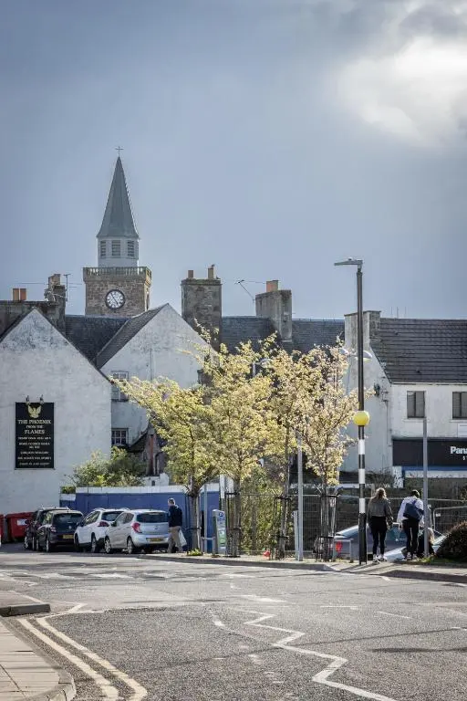 a city street with a building with a clock tower at The Inver Nest in Inverness