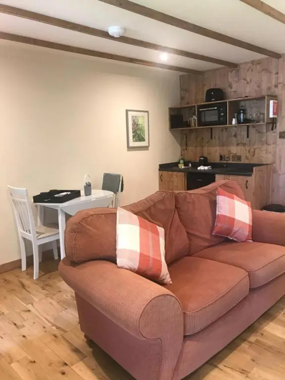 a living room with a brown couch and a table at Cosy Apartment in the Highlands in Muir of Ord