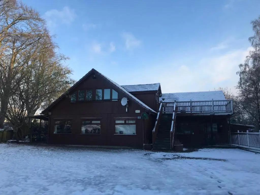 a house with snow on the ground in front of it at Cosy Apartment in the Highlands in Muir of Ord