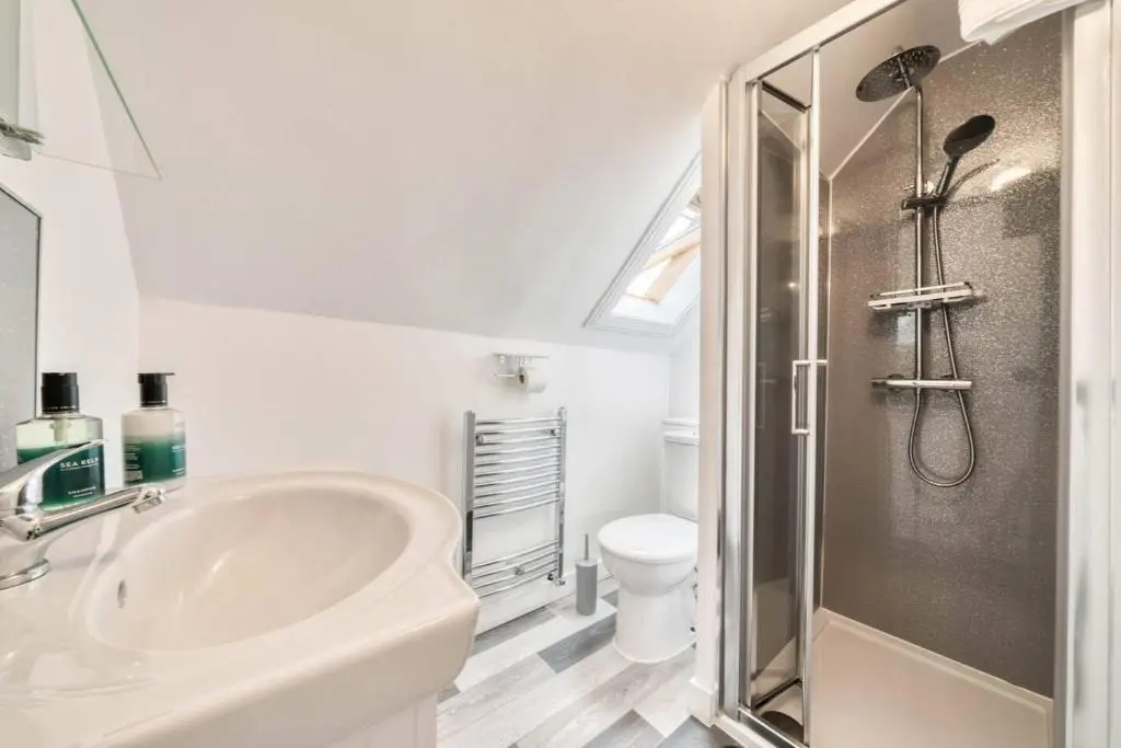 a white bathroom with a sink and a shower at Cloudhowe Cottage Ensuite Rooms & Studio Inverness in Inverness