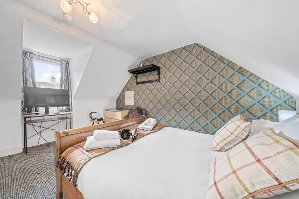 a bedroom with two beds and a tv at Cloudhowe Cottage Ensuite Rooms & Studio Inverness in Inverness