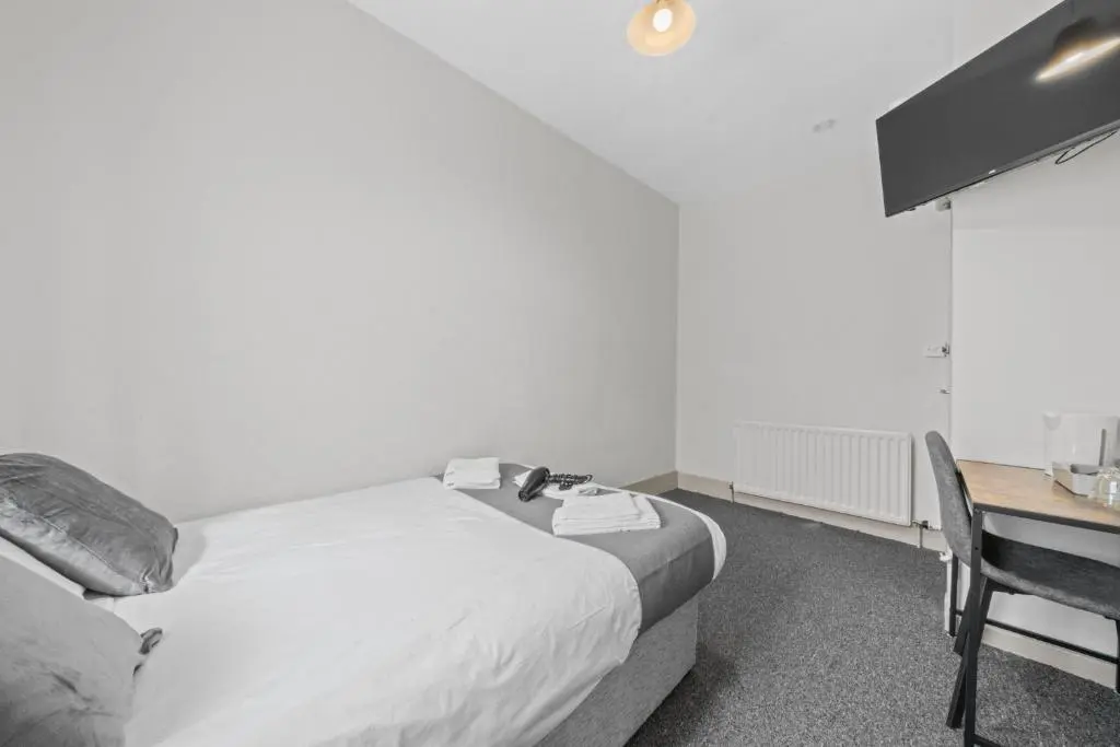 a bedroom with a bed and a desk with a desk at Haugh 4 Bedroom House - Inverness in Inverness