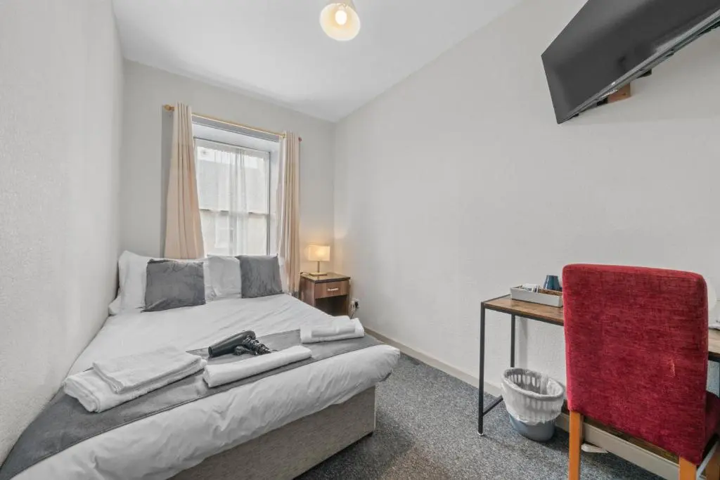 a bedroom with a bed and a desk and a window at Haugh 4 Bedroom House - Inverness in Inverness