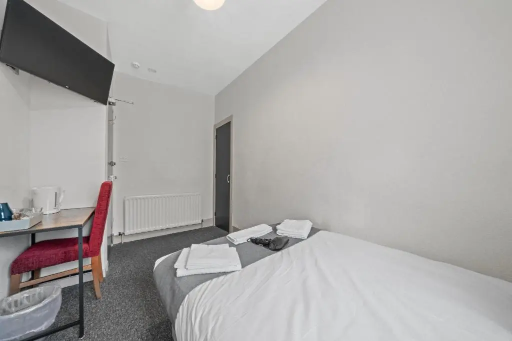 a bedroom with a bed and a desk with a red chair at Haugh 4 Bedroom House - Inverness in Inverness