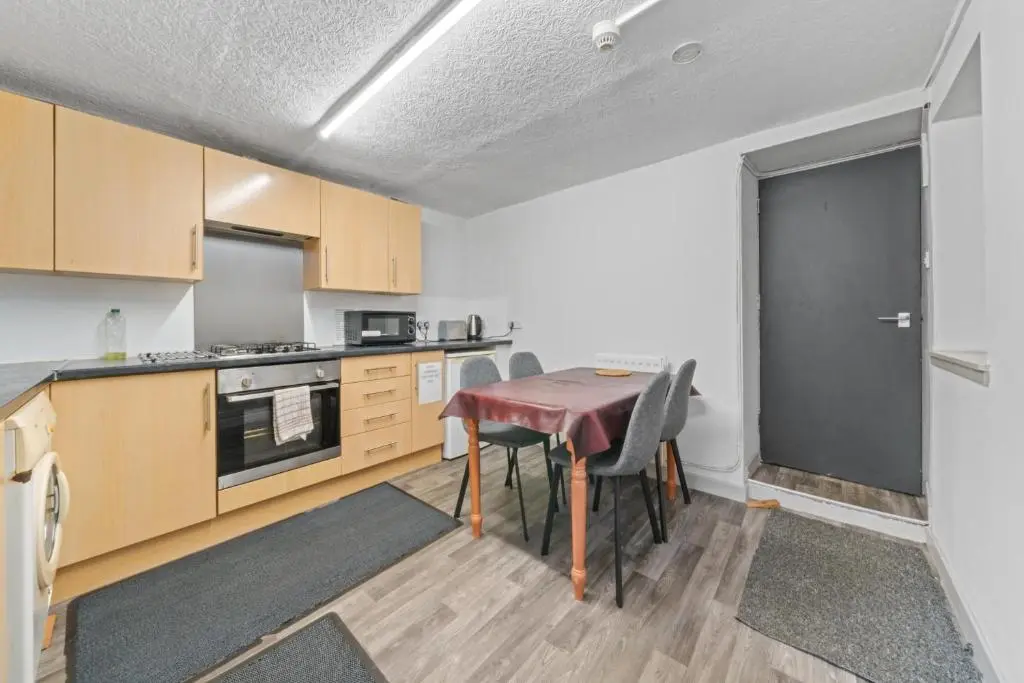a kitchen with a table and chairs in a room at Haugh 4 Bedroom House - Inverness in Inverness
