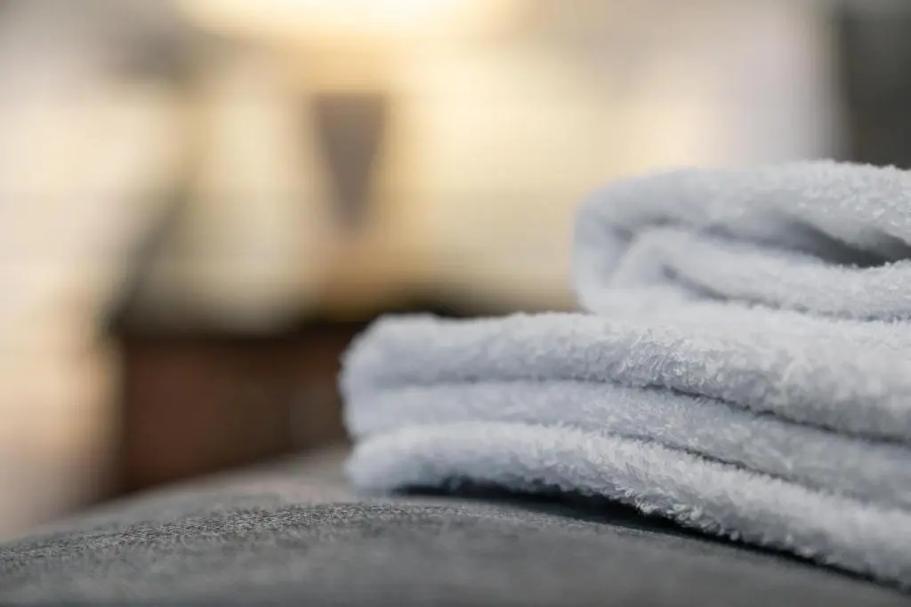 a pile of towels sitting on top of a bed at Central Inverness Hideaway - 2 Bedroom Flat in Inverness