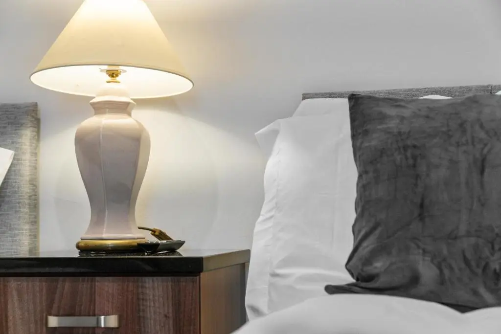a lamp on a night stand next to a bed at Central Inverness Hideaway - 2 Bedroom Flat in Inverness