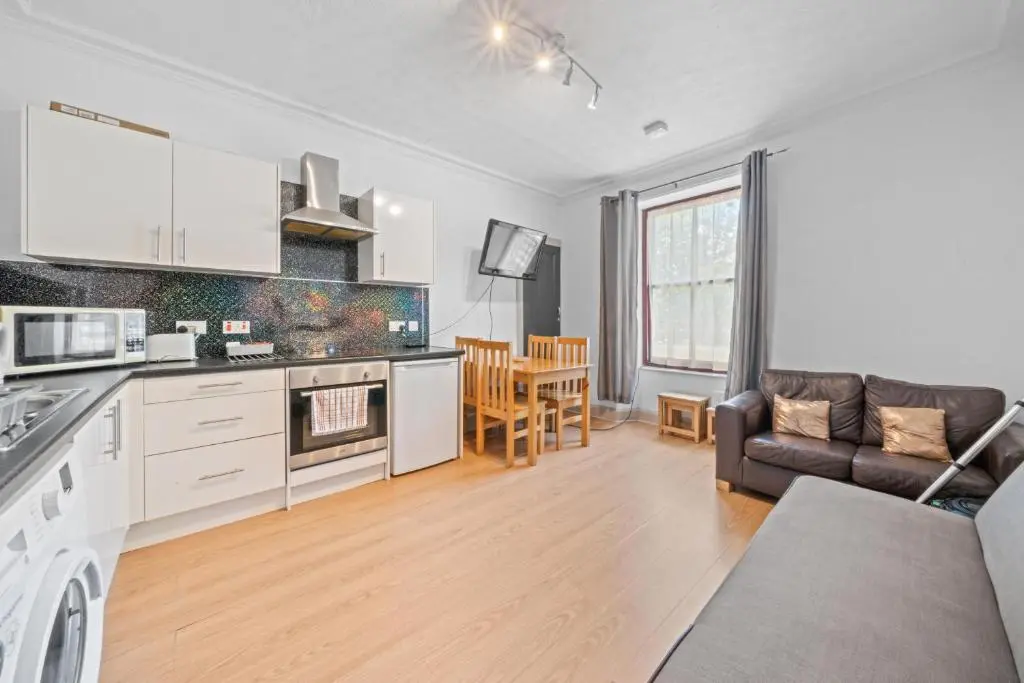 a kitchen and living room with a couch and a table at 2 Bedroom Inverness Apartment - Perfect Location in Inverness