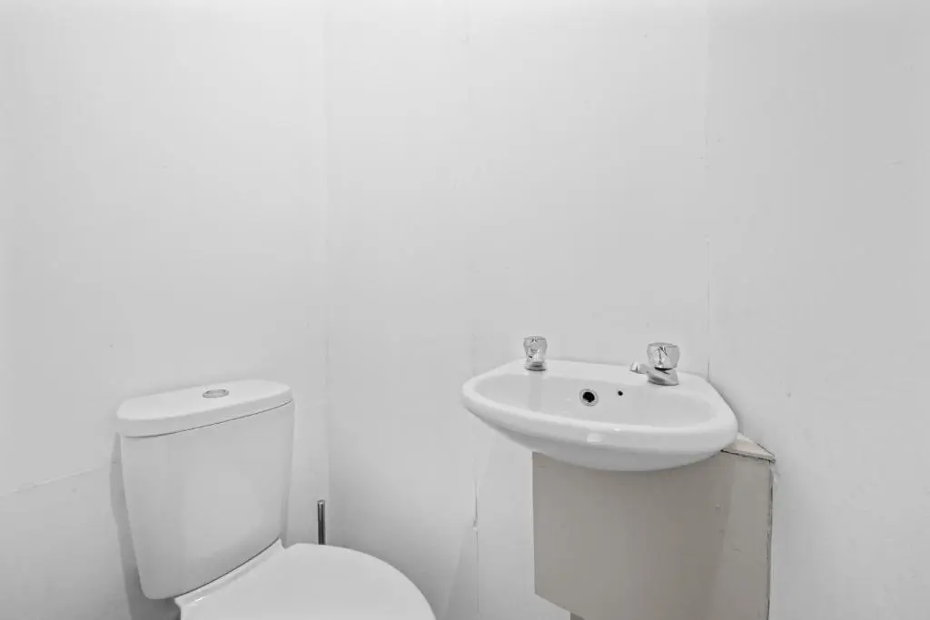 a white bathroom with a toilet and a sink at 2 Bedroom Inverness Apartment - Perfect Location in Inverness