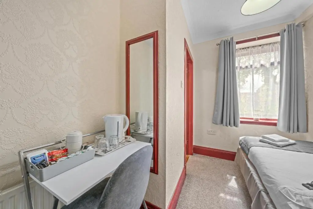 a room with a vanity and a mirror and a bed at Struy Guest House - Inverness in Inverness