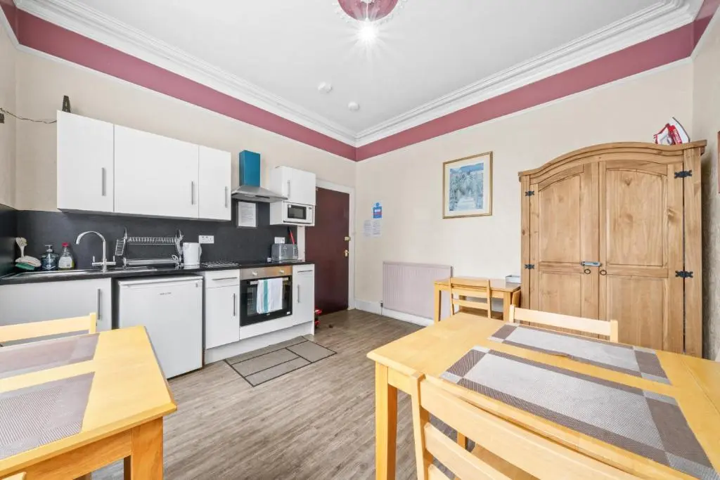 a kitchen and dining room with a table and chairs at Struy Guest House - Inverness in Inverness