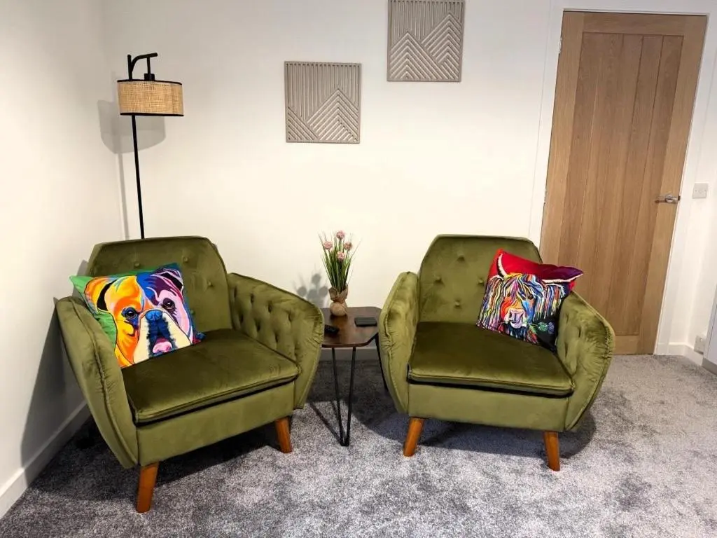 two green chairs and a table in a room at Meadowside-Stylish Newly Renovated 2 bed property in Insch
