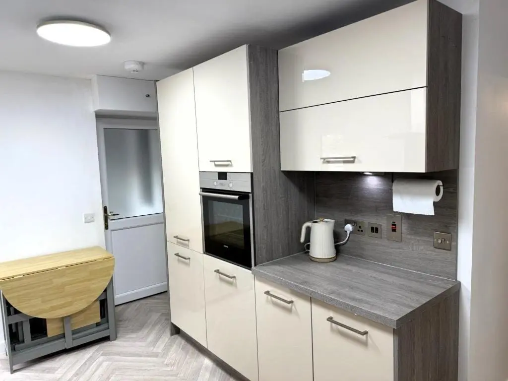 a kitchen with white cabinets and a counter top at Meadowside-Stylish Newly Renovated 2 bed property in Insch