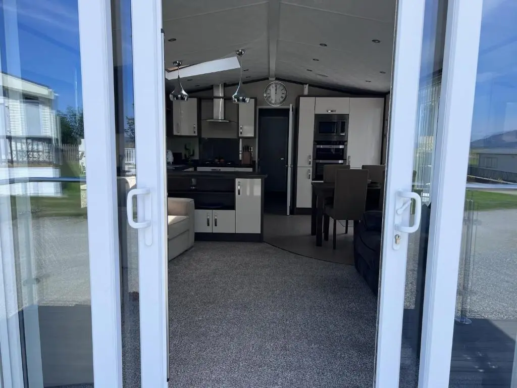 a view of a kitchen and dining room from a glass door at Drift Lodge in Tain