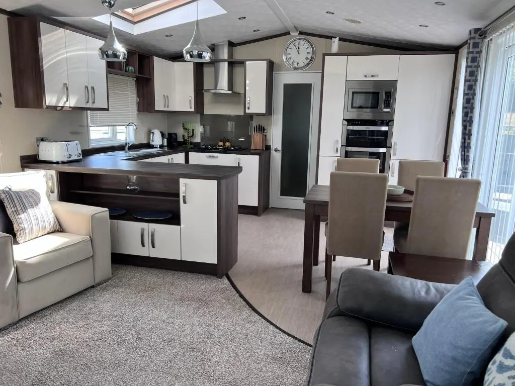 a kitchen and living room with a couch and a table at Drift Lodge in Tain