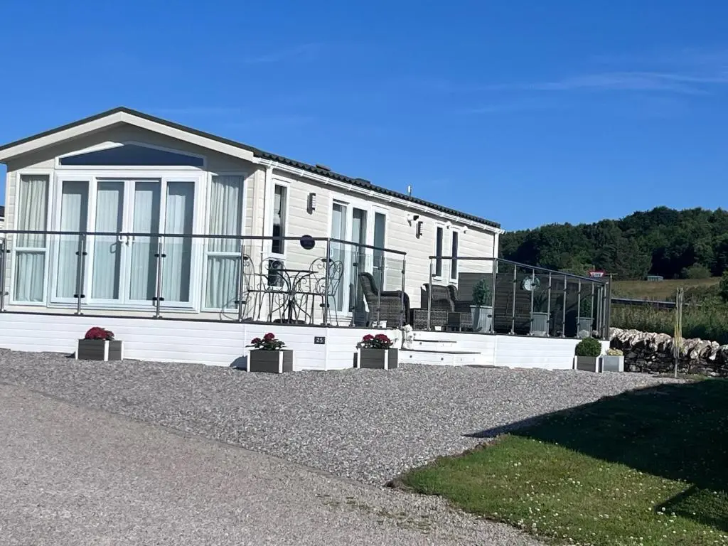 a white house with sheep in front of it at Drift Lodge in Tain
