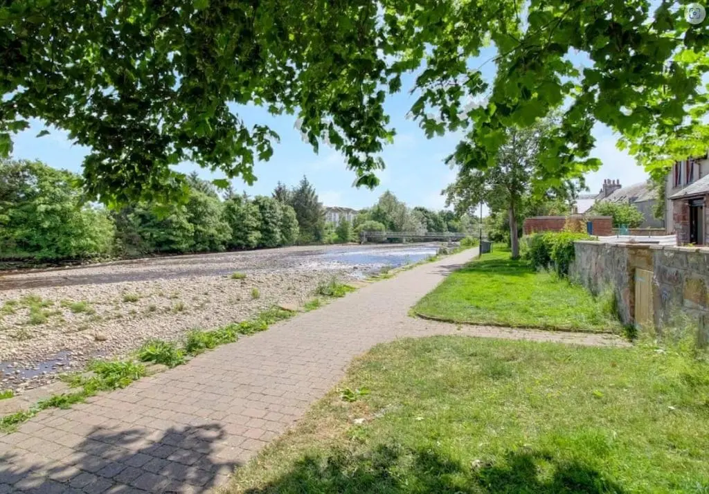 a brick path next to a road with a tree at River views 5 mins from beach in Nairn