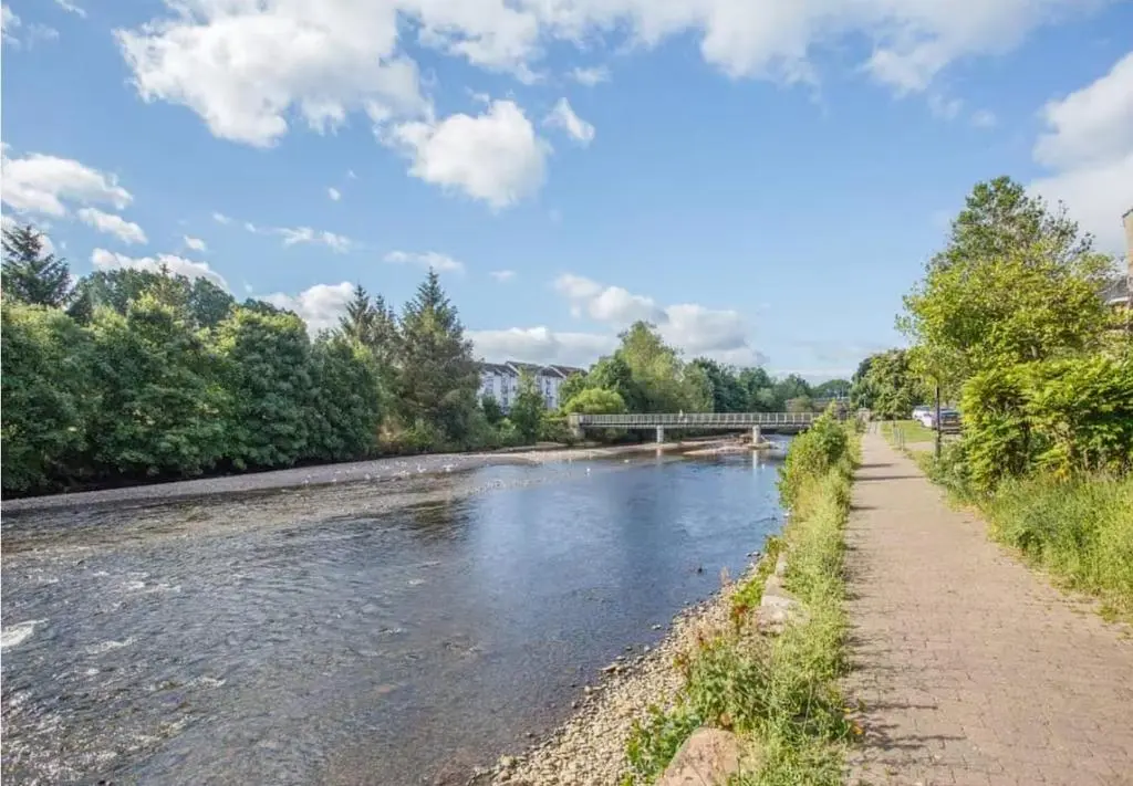 a river with a bridge in the background at River views 5 mins from beach in Nairn