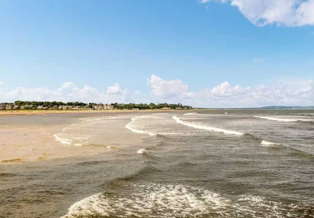 a beach with waves coming in from the ocean at River views 5 mins from beach in Nairn
