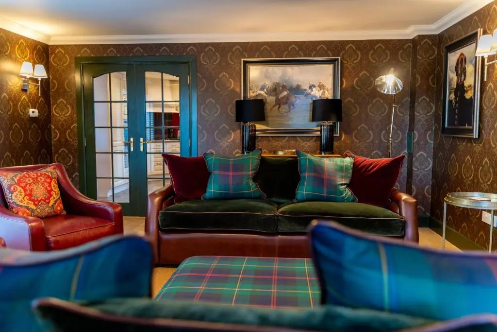 a living room with a couch and two chairs at The Hayloft in Braemar