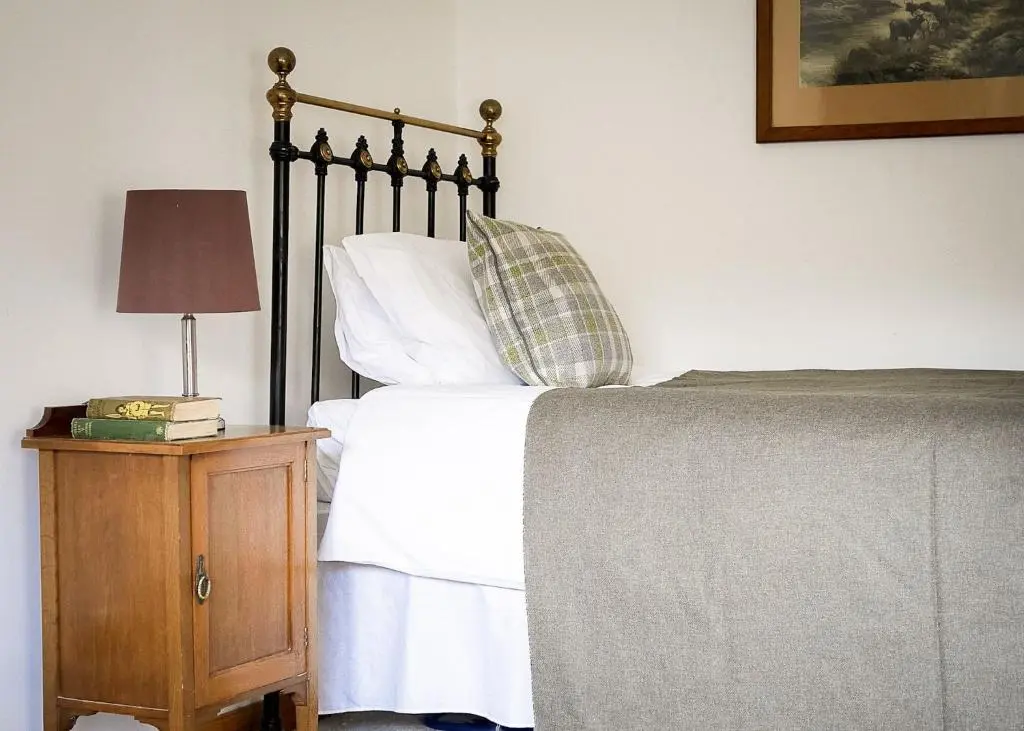 a bedroom with a bed and a table with a lamp at Relugas Mill in Forres