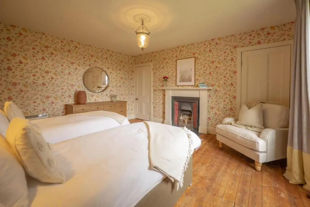 a bedroom with two beds and a couch and a fireplace at Laggandhu in Nethy Bridge