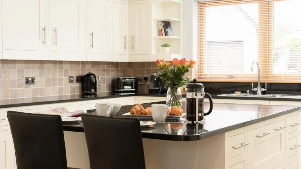 a kitchen with a table with a plate of food at Coorie Lodge in Aviemore