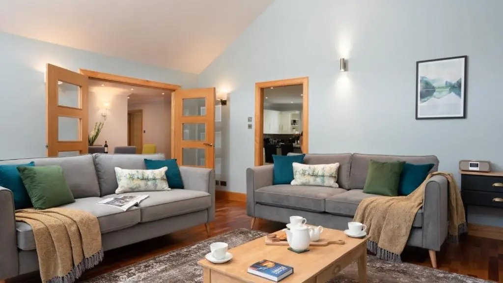 a living room with two couches and a coffee table at Coorie Lodge in Aviemore