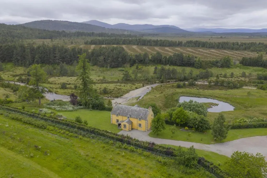 an aerial view of a house in a field at Drum Cottage in Nethy Bridge