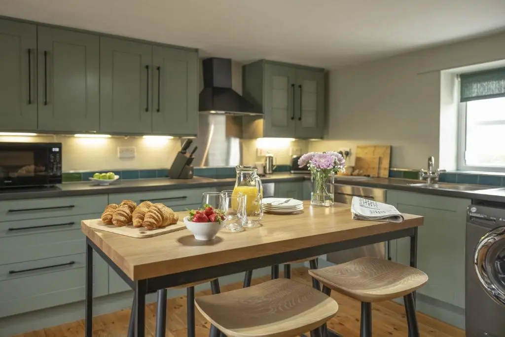 a kitchen with a wooden table with food on it at Ellon Cottage in Nethy Bridge