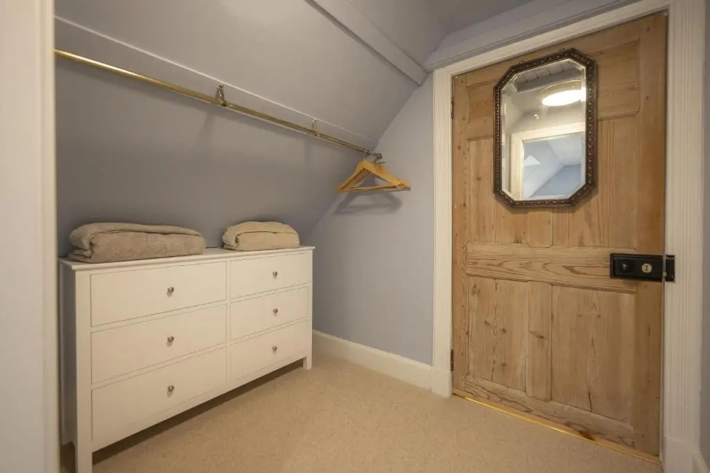 a bedroom with a dresser and a wooden door at Ellon Cottage in Nethy Bridge