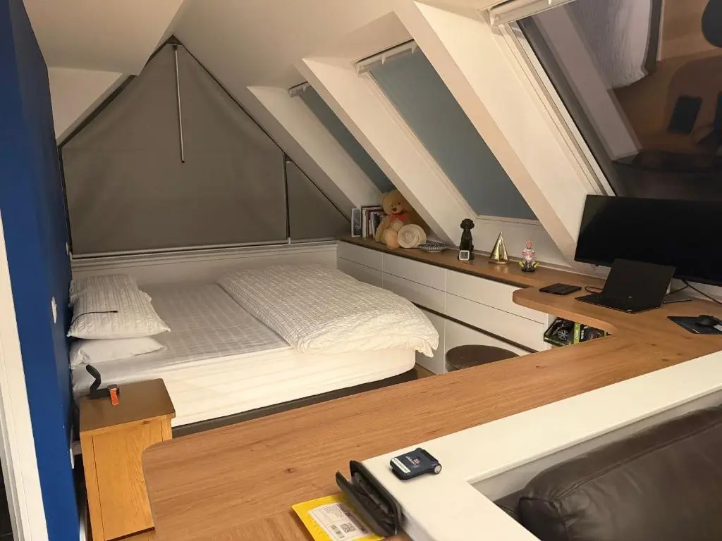a bedroom with a bed and a desk with a television at The Boathouse at Croft Downie in Archiestown