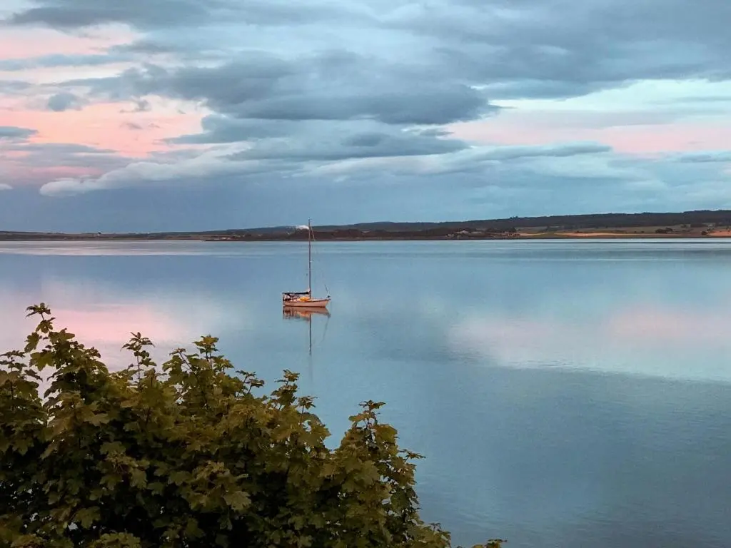 a boat sitting in the middle of a lake at The Boathouse at Croft Downie in Archiestown
