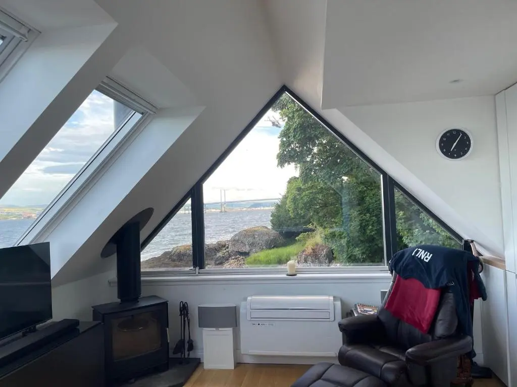 a room with a chair and a large window at The Boathouse at Croft Downie in Archiestown